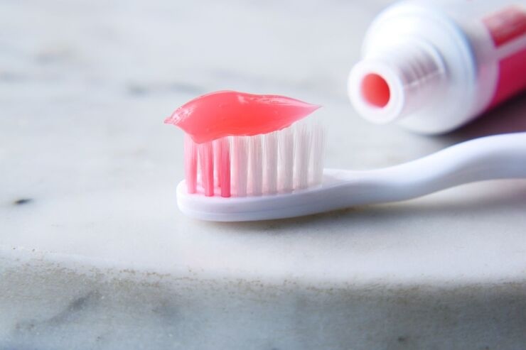 Spazzolino da denti con dentifricio rosa sopra 